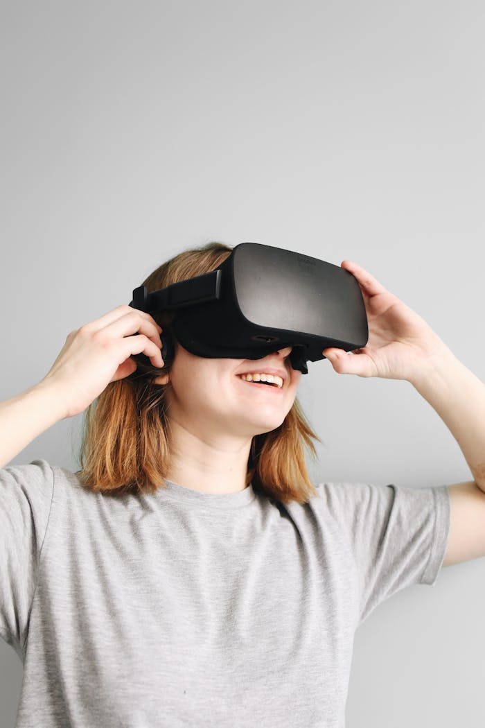 Smiling woman wearing a VR headset enjoys a virtual experience indoors.