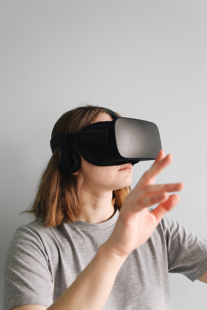 Adult woman using a virtual reality headset indoors, experiencing digital interaction.